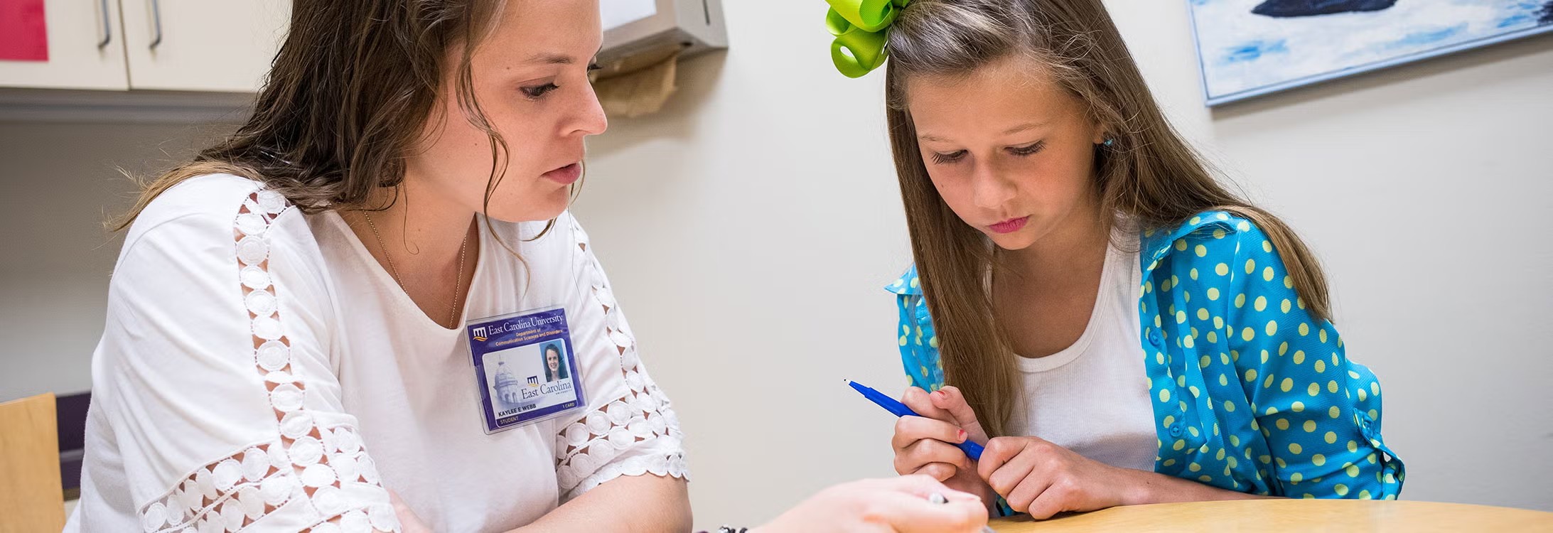 An adult and a child working together on a communication activity